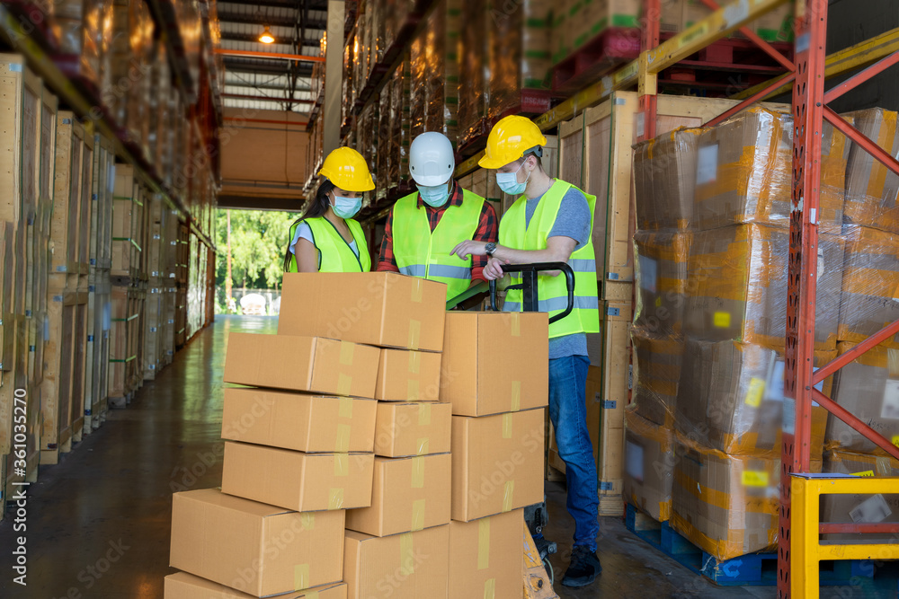Warehouse workers wearing protective mask to Protect Against Covid-19 with clipboard during work in a warehouse. Warehouse workers wearing protective mask to Protect Against Covid-19 with clipboard during work in a warehouse.