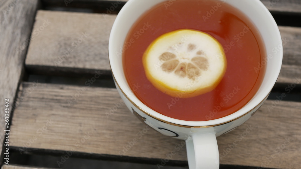 cup of tea with lemon on wooden table cup of tea with lemon on wooden table
