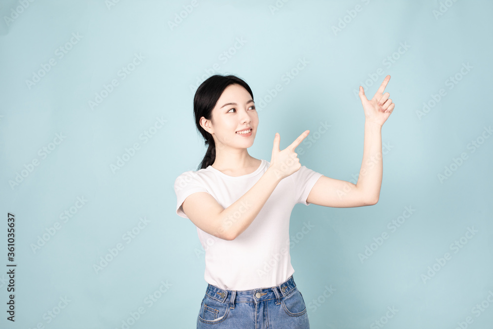 A young chinese woman in front of blue background A young chinese woman in front of blue background