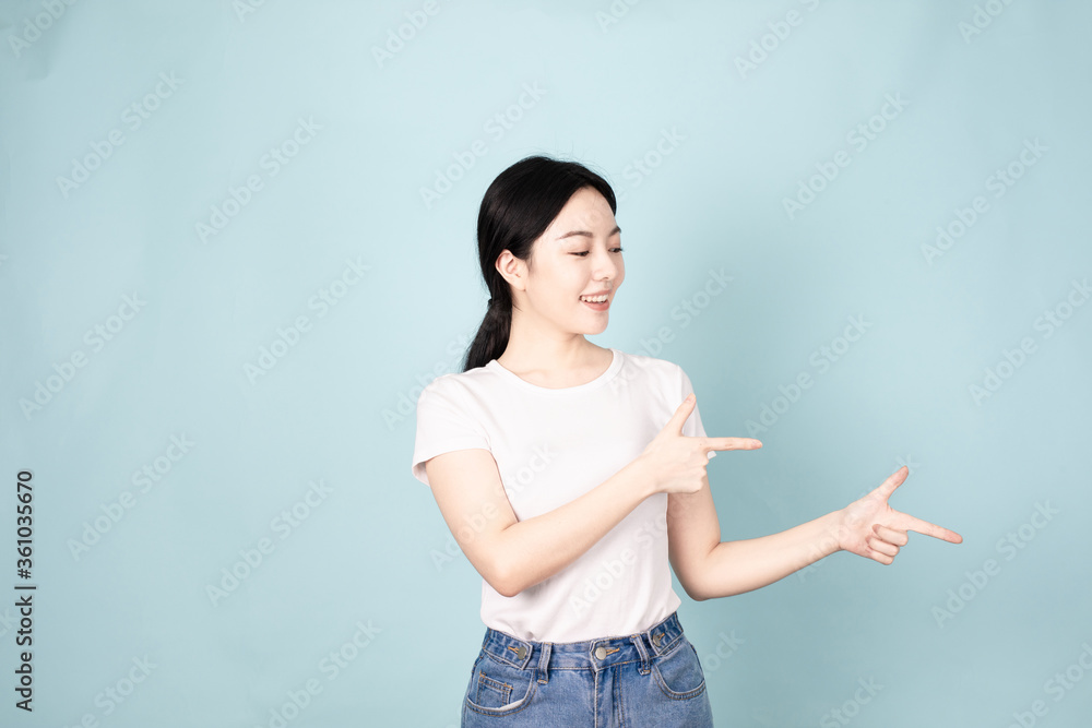A young chinese woman in front of blue background A young chinese woman in front of blue background