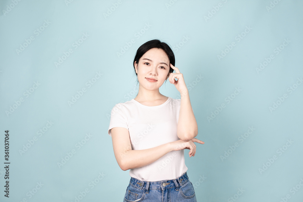 A young chinese woman in front of blue background A young chinese woman in front of blue background