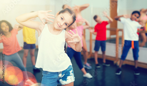 Fototapeta Naklejka Na Ścianę i Meble -  Girl exercising in group during dance class