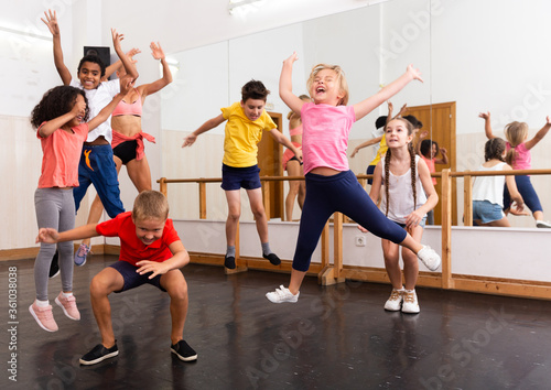 Fototapeta Naklejka Na Ścianę i Meble -  Happy sporty kids jumping together in dance studio