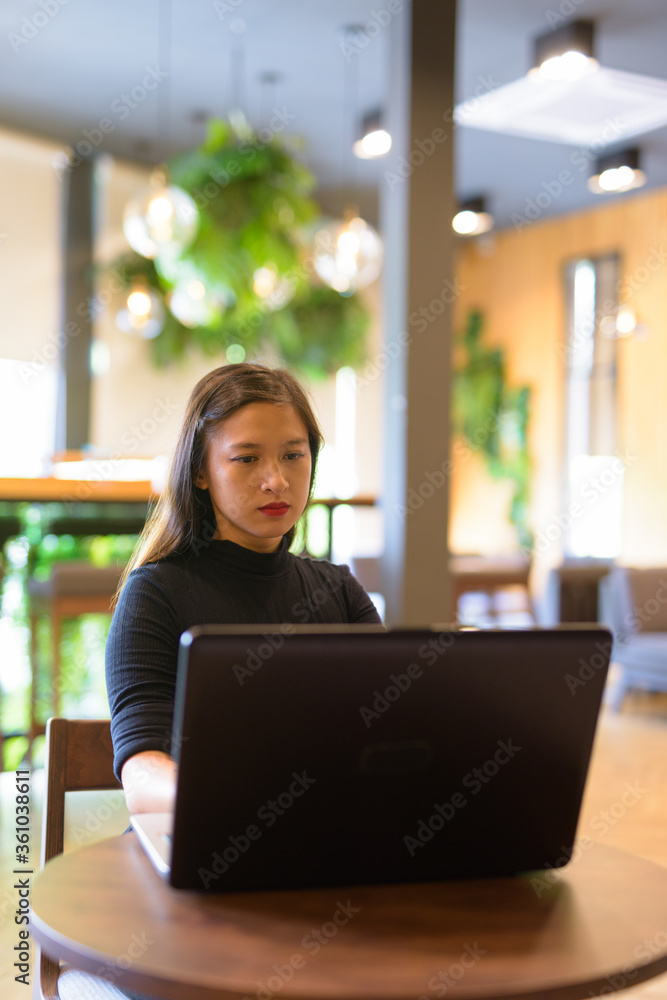 Φωτογραφία Young beautiful Asian businesswoman using laptop and sitting at the coffee shop