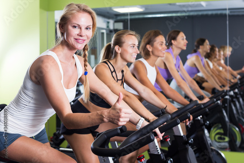 Satisfied women cycling in gym