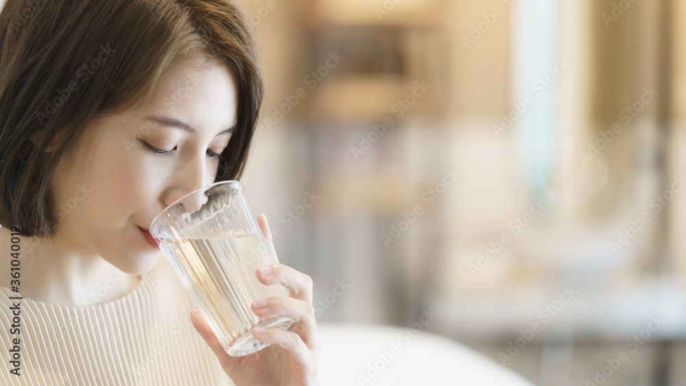 Woman holding transparent glass in her hand and drinking water. Woman holding transparent glass in her hand and drinking water.