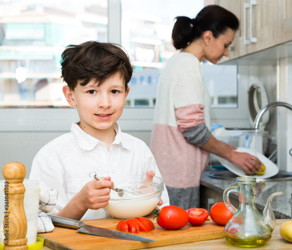 Boy preparing food with mother