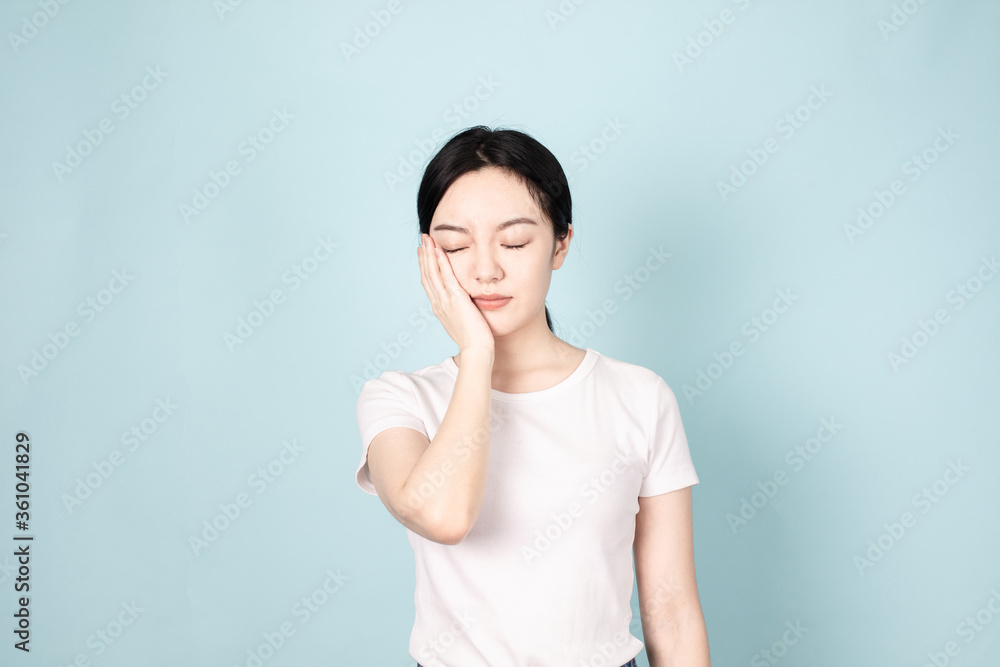 A young chinese woman in front of blue background A young chinese woman in front of blue background