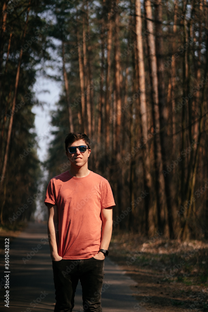 Handsome young man outdoor in park, walking in the park