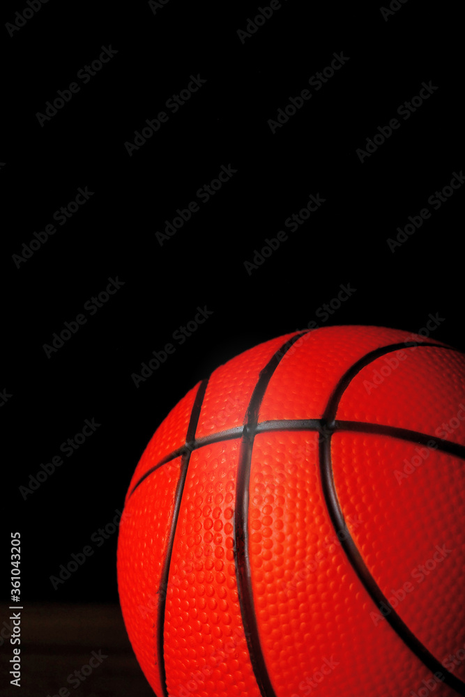 Fototapeta premium Basketball on a dark wooden floor, Dark background. Close up, Copy space.