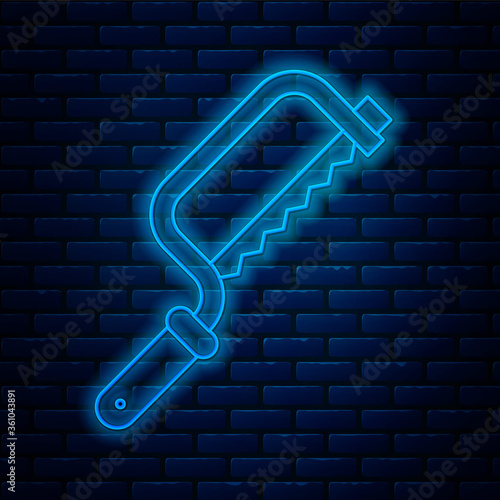 Glowing neon line Hacksaw icon isolated on brick wall background. Metal saw for wood and metal. Vector Illustration.