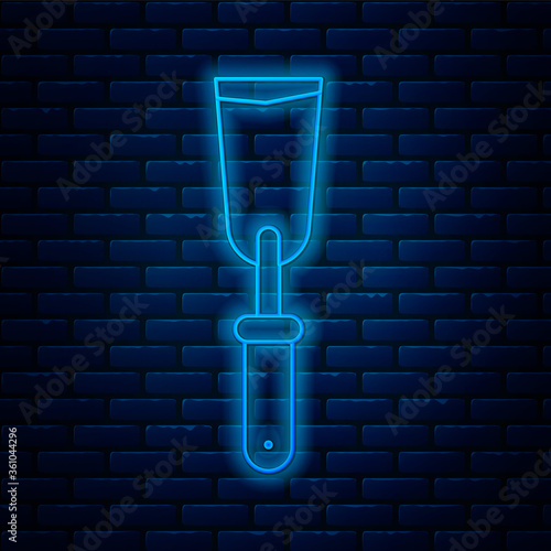 Glowing neon line Putty knife icon isolated on brick wall background. Spatula repair tool. Spackling or paint instruments. Vector Illustration.