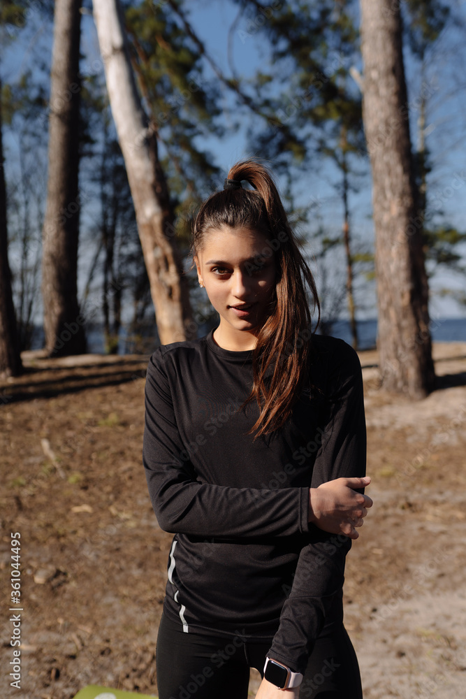Fitness young woman walks in the park and posing for the camera Fitness young woman walks in the park and posing for the camera