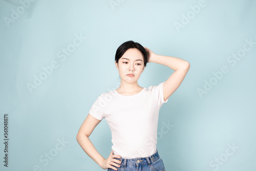 A young chinese woman in front of blue background © ACloud Man