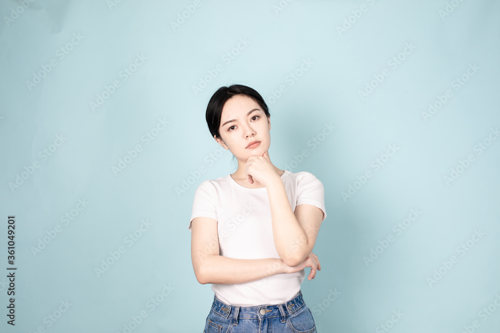 A young chinese woman in front of blue background A young chinese woman in front of blue background