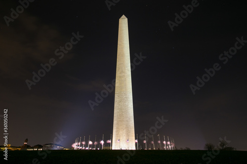 Washington Monument at night with lowered American flags around