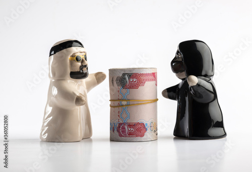 Rich Emirati couple - a concept. Figures of an Emirati couple embracing money. photo