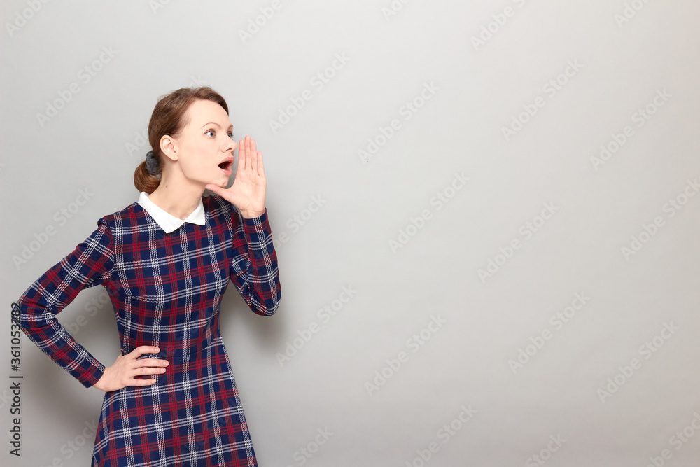 Portrait of amazed girl screaming loudly to side with hand near mouth Portrait of amazed girl screaming loudly to side with hand near mouth