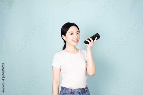 A Young Chinese Woman In Front of Blue Background