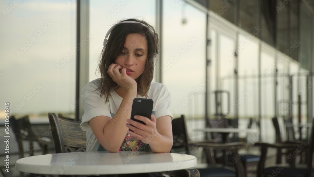 Young woman in headphones looking at the smartphone
