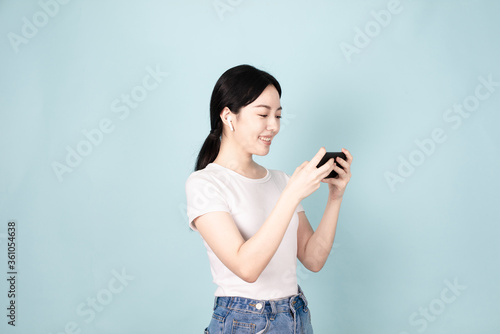 A Young Chinese Woman In Front of Blue Background