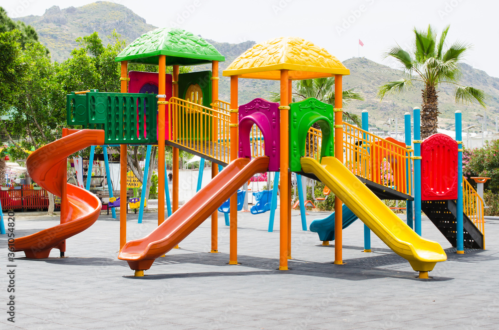 Empty children playground activities in public park surrounded by green trees. Empty children playground activities in public park surrounded by green trees.