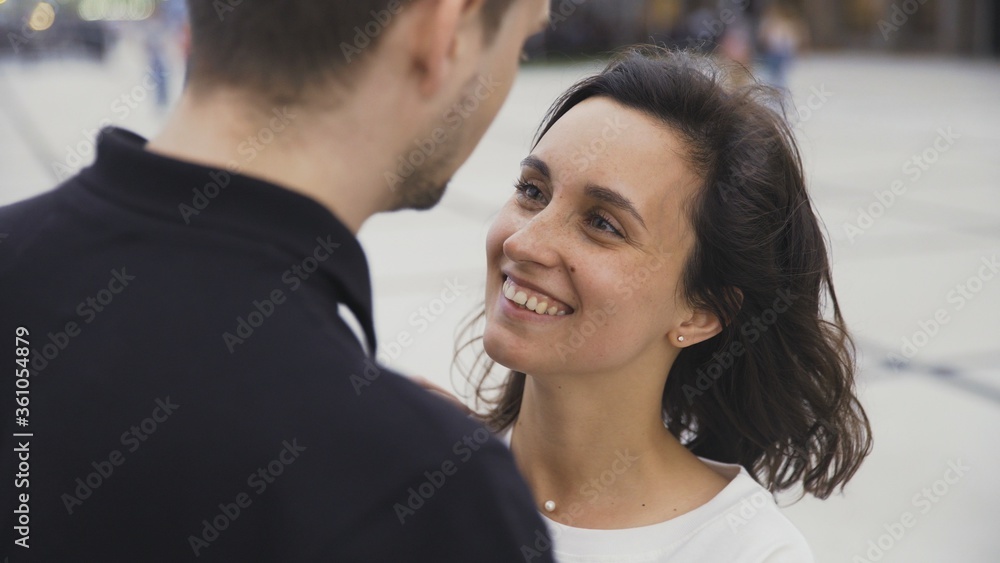 Portrait of attractive couple standing at the city street and looking to each other Portrait of attractive couple standing at the city street and looking to each other