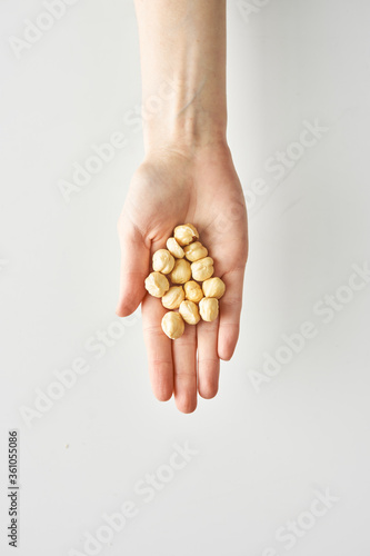 Healthy snack of hazelnuts in hand isolated on white background, healthy food and lifestyle,100 calories portion 