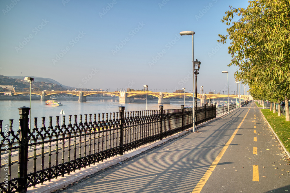 Sidewalk along Danube river with view to Margaret Bridge, Budapest.