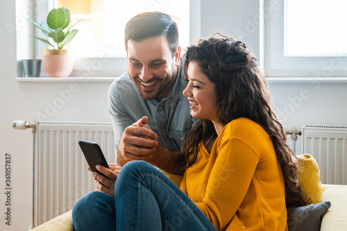 Happy couple looking mobile phone together stock photo
