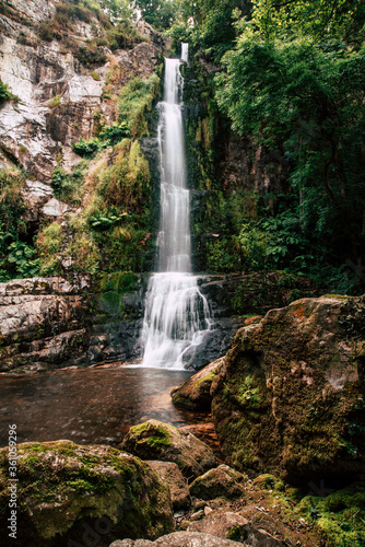 Landscape of one of water cascades of Oneta waterfalls in picturesque forest of Asturias, Spain.