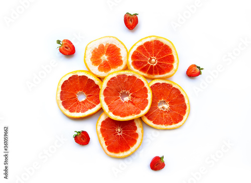 Grapefruits and strawberry on white background  top view. Citrus fruits. Slices of fresh orange