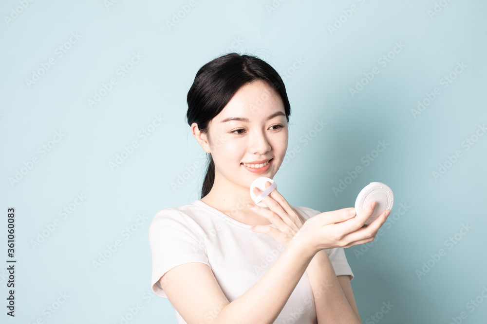 A Young Chinese woman in front of a blue background A Young Chinese woman in front of a blue background
