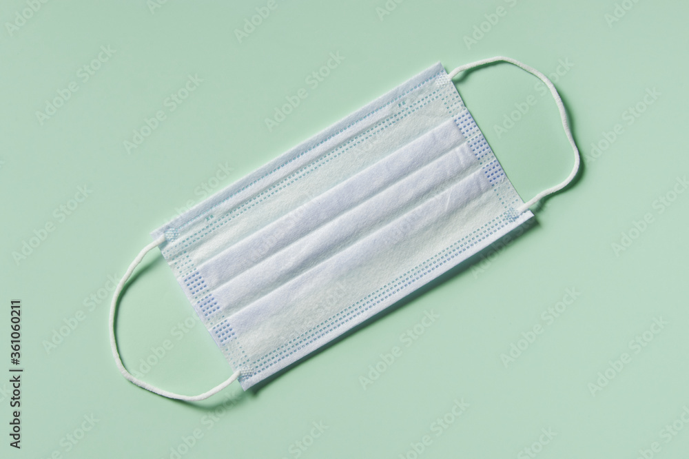 medicine, healthcare and pharmacy concept - medical mask lies on mint green background top view copy space medicine, healthcare and pharmacy concept - medical mask lies on mint green background top view copy space