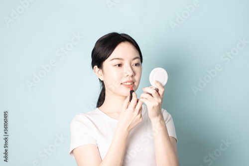 A Young Chinese woman in front of a blue background