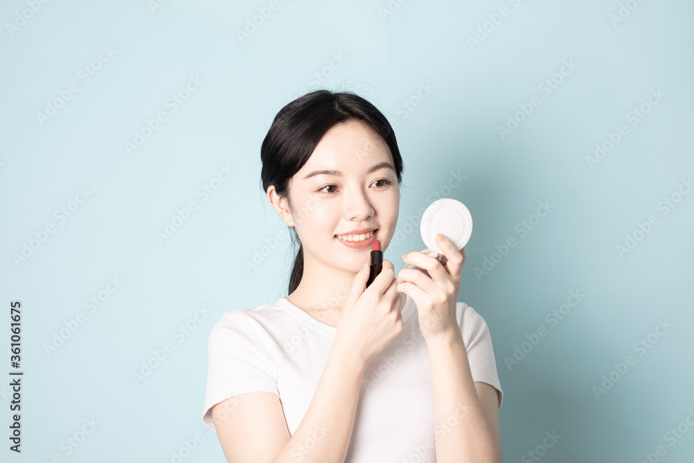 A Young Chinese woman in front of a blue background A Young Chinese woman in front of a blue background
