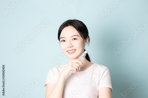 A Young Chinese woman in front of a blue background