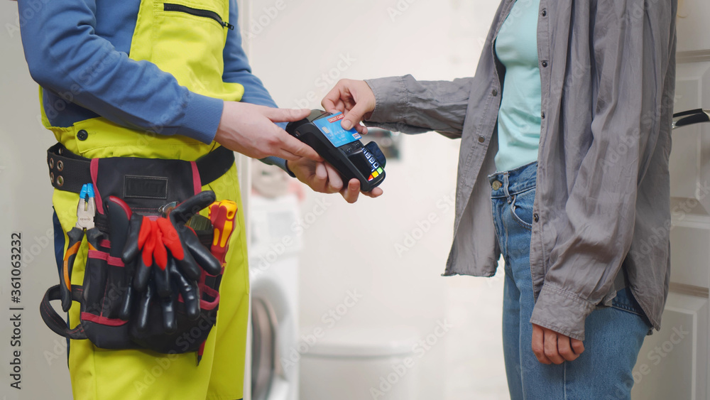 Housewife playing for repairman work using credit card Housewife playing for repairman work using credit card