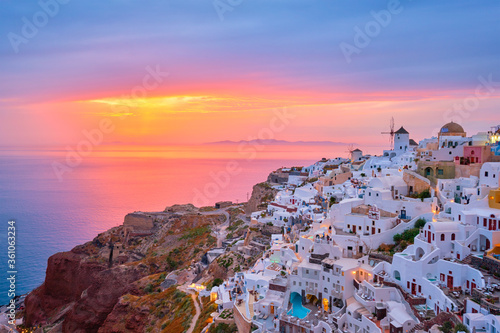 Famous greek iconic selfie spot tourist destination Oia village with traditional white houses and windmills in Santorini island on sunset in twilight, Greece © Dmitry Rukhlenko