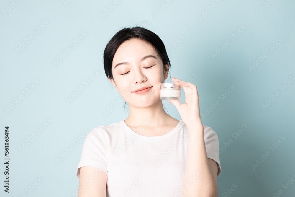 A Young Chinese woman in front of a blue background A Young Chinese woman in front of a blue background