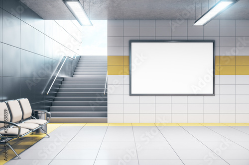 Fototapeta Chairs for waiting in modern metro station with blank poster.