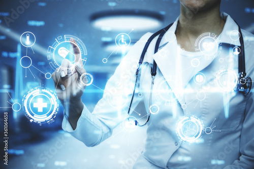 Doctor with stethoscope using glowing medical icons interface.