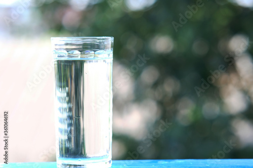 glass of water on wood table background and pouring drinking water