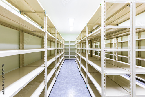 Empty white metal shelves in storage room