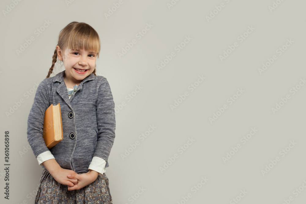Cheerful school girl smiling on white banner background with copy space Cheerful school girl smiling on white banner background with copy space