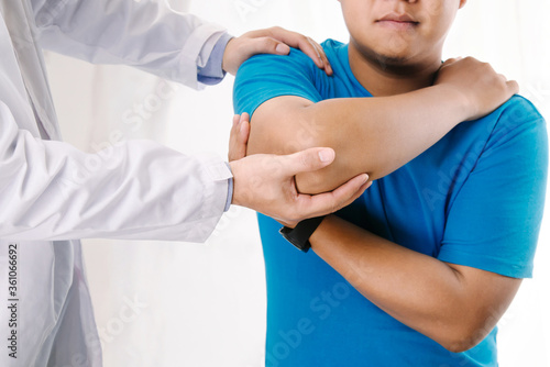 Doctor physiotherapist consulting with patient about elbow muscle pain problems.Physical therapy diagnosing concept