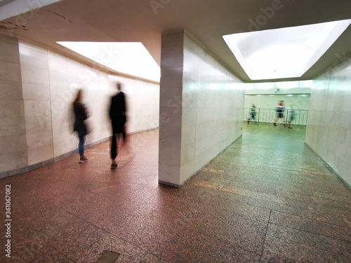 Blurred movement of people in the subway corridor.