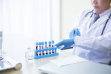 Doctor wearing glove preparing blood sampling tube, Covid19 pandemic vaccine concept
