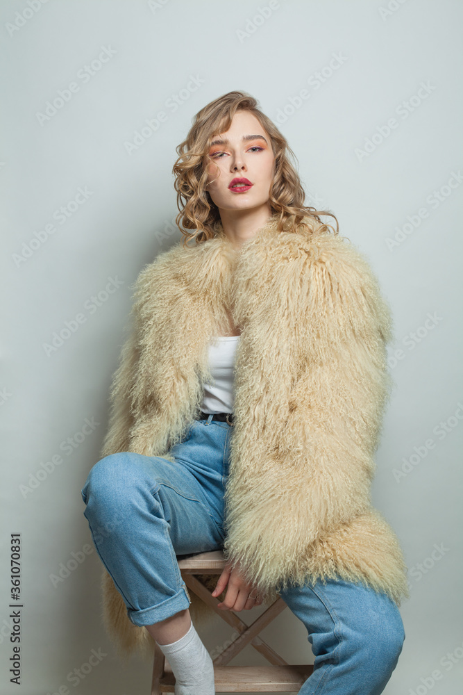 Nice woman wearing white fashionable coat posing on white background Nice woman wearing white fashionable coat posing on white background