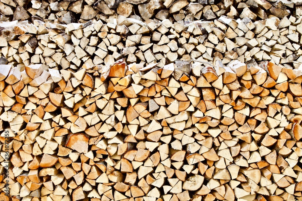 Stacked firewood close-up. Firewood storage close up. Stocks of wooden logs close-up. Chopping wood. Logging in the village. Rustic lifestyle. Woodpile with firewood full frame image. Wooden texture. Stacked firewood close-up. Firewood storage close up. Stocks of wooden logs close-up. Chopping wood. Logging in the village. Rustic lifestyle. Woodpile with firewood full frame image. Wooden texture.